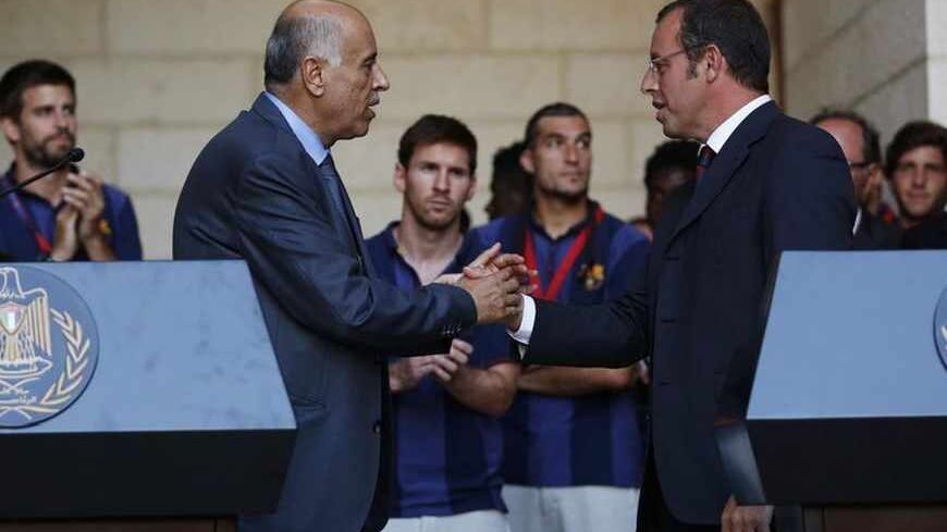 Barcelona President Sandro Rosell (R) and Palestinian Football Association President Jibril Rajoub shake hands after addressing members of the media at the start of a visit by the soccer team at the Palestinian President's office in the West Bank town of Bethlehem August 3, 2013. Barcelona is on a two-day "Peace Tour" in the region, which will include conducting soccer clinics for young people.
REUTERS/Mohamad Torokman (WEST BANK - Tags: SPORT SOCCER) - RTX129MC