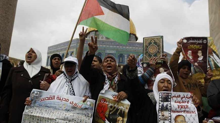 Palestinians hold placards during a protest calling for the release of Palestinian prisoners held in Israeli jails after Friday prayers in Jerusalem's Old City April 19, 2013. The Dome of the Rock on the compound known to Muslims as al-Haram al-Sharif, and to Jews as Temple Mount, is seen in the background. REUTERS/Ammar Awad (JERUSALEM - Tags: POLITICS CIVIL UNREST) - RTXYS75