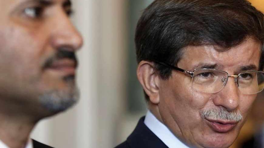 Turkey's Foreign Minister Ahmet Davutoglu (R) speaks as the head of the opposition Syrian National Coalition Ahmed Jarba listens during a news conference in Istanbul August 24, 2013.  REUTERS/Murad Sezer (TURKEY - Tags: POLITICS) - RTX12UZX