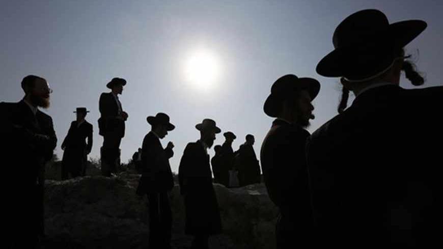 Ultra-Orthodox protesters pray during clashes in the town of Beit Shemesh, near Jerusalem August 14, 2013. Ultra-Orthodox protesters clashed on Wednesday with police and other security forces in the town of Beit Shemesh after a group of them broke into a construction site to prevent work from taking place at the site they believe contains ancient graves. REUTERS/ Baz Ratner (ISRAEL - Tags: RELIGION CIVIL UNREST POLITICS TPX IMAGES OF THE DAY) - RTX12L8W