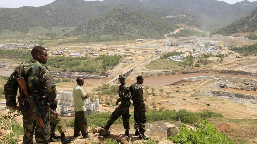 Security guards look at the construction of Ethiopia's Great Renaissance Dam in Guba Woreda, some 40 km (25 miles) from Ethiopia's border with Sudan, June 28, 2013. Egypt fears the $4.7 billion dam, that the Horn of Africa nation is building on the Nile, will reduce a water supply vital for its 84 million people, who mostly live in the Nile valley and delta. Picture taken June 28, 2013. REUTERS/Tiksa Negeri (ETHIOPIA - Tags: POLITICS SOCIETY ENERGY ENVIRONMENT) - RTX115K8