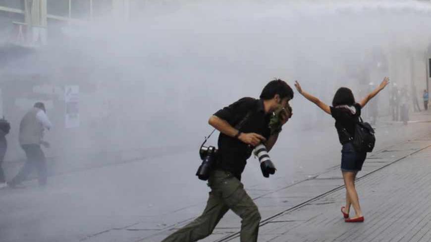 Riot police use a water cannon to disperse demonstrators during a protest in central Istanbul July 6, 2013. Turkish police fired teargas and water cannon to disperse hundreds of protesters in an Istanbul square on Saturday as they gathered to enter a park that was the centre of protests against Prime Minister Tayyip Erdogan last month. REUTERS/Murad Sezer (TURKEY - Tags: POLITICS CIVIL UNREST) - RTX11F1Y