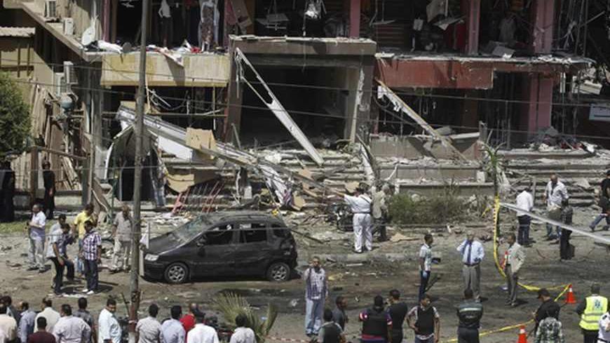 Policemen investigate the site of a bomb attack and assassination attempt near the house of Egypt's Interior Minister Mohamed Ibrahim in the Nasr City district of Cairo September 5, 2013. Ibrahim survived an assassination attempt unscathed on Thursday when a car bomb blew up his convoy and he said afterwards that a wave of terrorism by opponents of the military-installed government was just beginning. REUTERS/Amr Abdallah Dalsh (EGYPT - Tags: POLITICS CIVIL UNREST) - RTX138EV