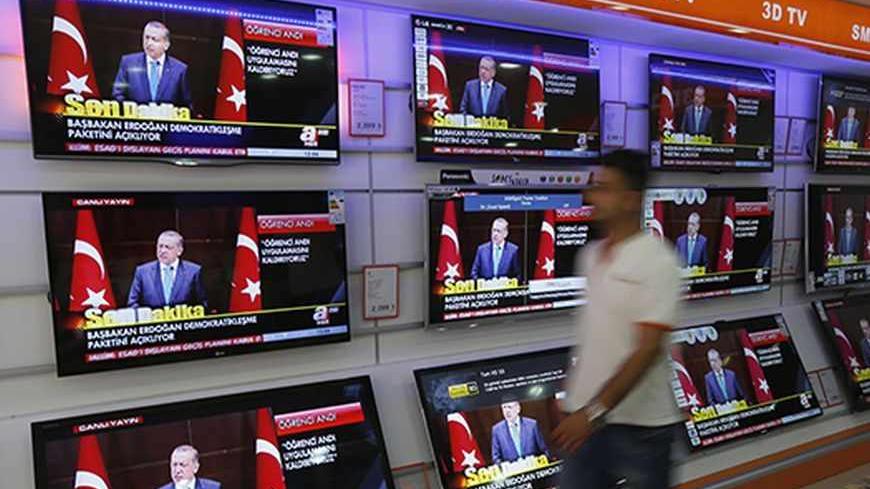 A televised news conference of Turkish Prime Minister Tayyip Erdogan is screened on televisions at an electronics shop in Istanbul September 30, 2013. Turkey may reduce the threshold for a political party to enter parliament to 5 percent of the national vote, or even eliminate the barrier completely, Erdogan said on Monday. The current 10 percent threshold has kept pro-Kurdish groupings outside of parliament and a reform that may help advance a flagging peace process with Kurdish militants. In a major polic