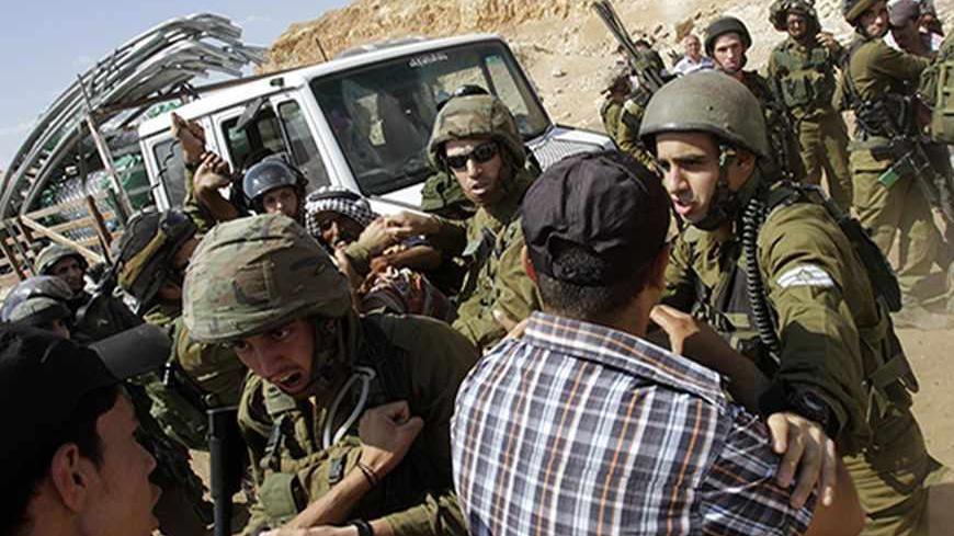 Israeli soldiers scuffle with Palestinians near a truck loaded with items European diplomats wanted to deliver to locals in the West Bank herding community of Khirbet al-Makhul, in the Jordan Valley September 20, 2013. Israeli soldiers manhandled European diplomats on Friday and seized a truck full of tents and emergency aid they had been trying to deliver to Palestinians whose homes were demolished earlier this week. REUTERS/Abed Omar Qusini (WEST BANK - Tags: POLITICS CIVIL UNREST MILITARY) - RTX13SGZ
