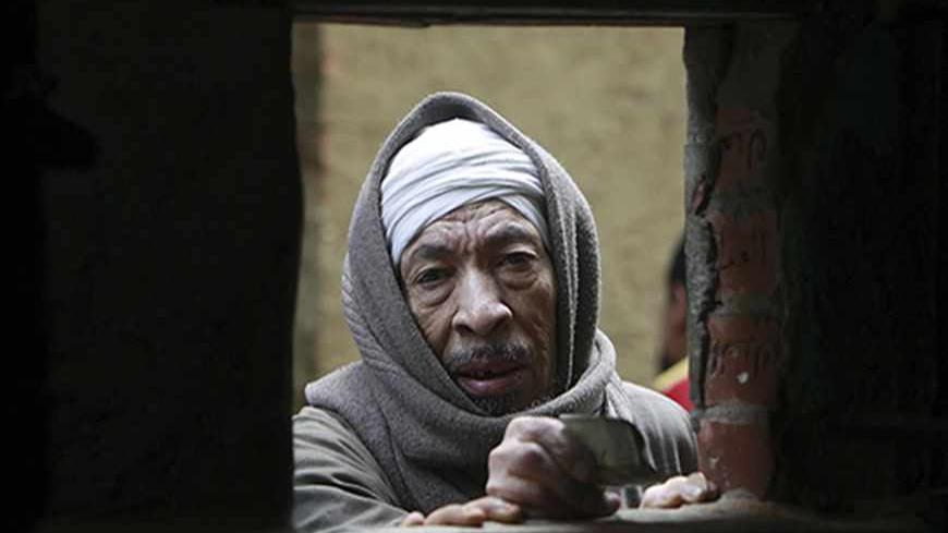 A man offers money to buy bread at a bakery in Cairo March 17, 2013. The spectre of steep food price inflation driven by a weaker pound is of particular worry to President Mohamed Mursi as he grapples with spasms of unrest two years after the uprising that toppled Hosni Mubarak and was itself partly driven by a sense of mounting economic hardship in a country long steeped in poverty. REUTERS/Mohamed Abd El Ghany (EGYPT - Tags: POLITICS BUSINESS FOOD) - RTR3F42I