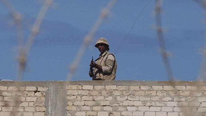 An Egyptian soldier guards the border between Egypt and southern Gaza Strip September 16, 2013. The Egyptian army is clearing buildings deemed a security threat at a distance of up to one km (0.6 miles) from the Gaza border, an army spokesman said on Sunday, accusing groups in the Hamas-run territory of mounting joint attacks with Sinai militants. REUTERS/Ibraheem Abu Mustafa (EGYPT - Tags: POLITICS MILITARY) - RTX13N6S