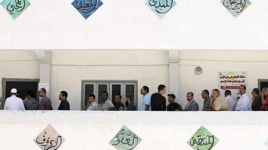 Egyptians stand in a line to cast their votes during the presidential elections in the Mediterranean city of Alexandria, 230 km (143 miles) north of Cairo May 24, 2012. Egyptians, choosing their leader freely for the first time in history, voted for a second day on Thursday in an election that is a fruit of last year's popular revolt against Hosni Mubarak.  REUTERS/Mohamed Abd El-Ghany  (EGYPT - Tags: POLITICS ELECTIONS) - RTR32KCR