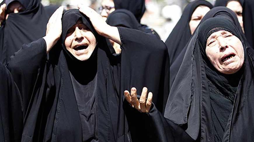 Shi'ite women react during a mass funeral for victims of Wednesday's bomb attacks on a Shi'ite mosque in Baghdad September 12, 2013. The co-ordinated car and suicide bomb attack on the Shi'ite mosque in the Iraqi capital killed at least 33 people on Wednesday evening, police and medical sources said. REUTERS/Thaier Al-Sudani (IRAQ - Tags: POLITICS CIVIL UNREST) - RTX13IL5