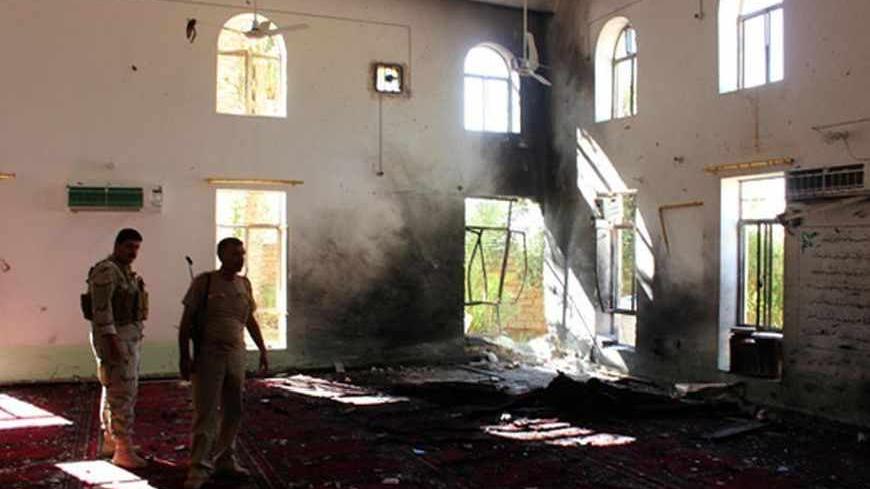 Iraqi security forces stand inside a Sunni mosque at the site of a suicide bomber attack in the town of Wajihiya in the ethnically and religiously diverse province of Diyala, July 20, 2013. A suicide bomber blew himself up inside a Sunni mosque in central Iraq, killing at least 20 people in the middle of a sermon on Friday.  REUTERS Mohammed Adnan (IRAQ - Tags: CIVIL UNREST POLITICS) - RTX11SM4