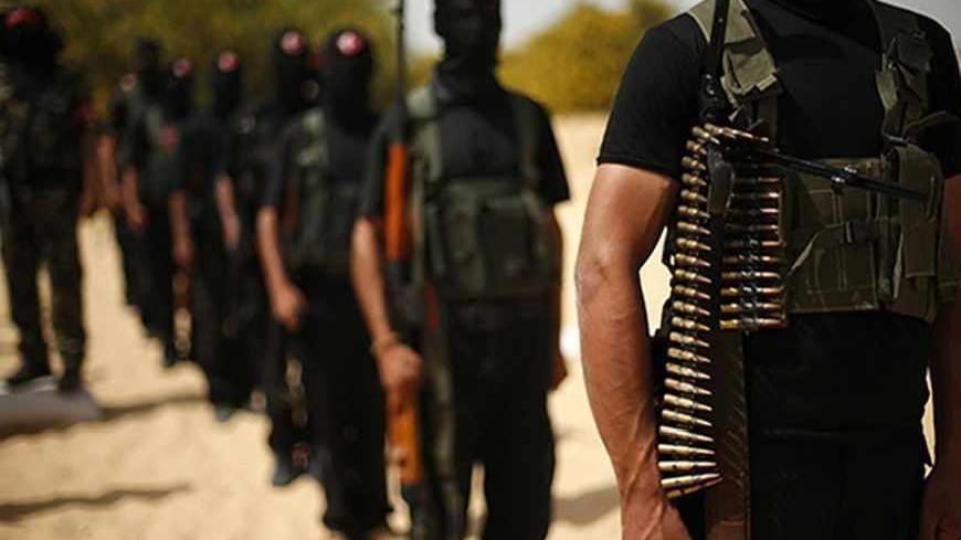Palestinian militants of the Popular Front for the Liberation of Palestine (PFLP) stand with their weapons at a demonstration during a military graduation ceremony in front of the media in Khan Younis in the southern Gaza Strip March 13, 2013. REUTERS/Suhaib Salem (GAZA - Tags: POLITICS CIVIL UNREST MILITARY) - RTR3EX78