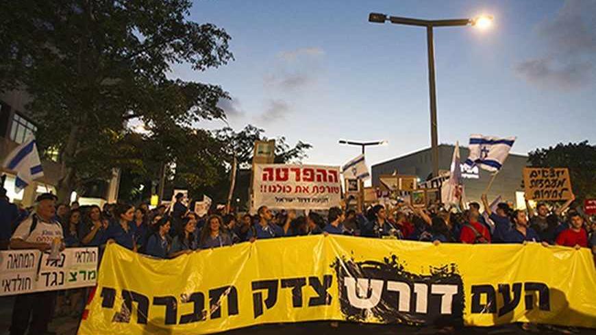 Protesters hold a placard in Hebrew reading, "the People demand social justice" during a demonstration calling for social justice in Tel Aviv June 30, 2012.    REUTERS/Nir Elias (ISRAEL - Tags: POLITICS CIVIL UNREST SOCIETY) - RTR34F92