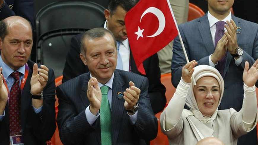 Turkey's Prime Minister Recep Tayyip Erdogan (2nd L) and his wife Emine Erdogan attend the women's qualification game Olympic basketball match between Turkey and Angola during the London 2012 Olympic Games July 28, 2012. REUTERS/Luke MacGregor (BRITAIN - Tags: POLITICS SPORT OLYMPICS BASKETBALL) - RTR35I0J