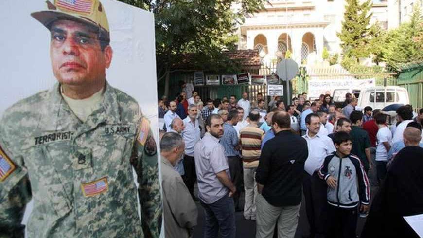 A man holds posters depicting Egypt's top general, Abdel Fattah al-Sisi as Turkish supporters of Egypt's ousted President Mohammed Morsi demonstrate outside the Egyptian embassy in Ankara on August 8, 2013. AFP PHOTO / ADEM ALTAN (Photo credit should read ADEM ALTAN/AFP/Getty Images)