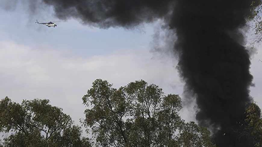A helicopter flies as smoke rises over Westgate shopping centre after an explosion in Nairobi, September 23, 2013. Powerful explosions sent thick smoke billowing from the Nairobi mall where militants from Somalia's al Qaeda-linked al Shabaab group threatened to kill hostages on the third day of a raid in which at least 59 have already died. REUTERS/Karel Prinsloo (KENYA - Tags: CIVIL UNREST CRIME LAW) - RTX13WO3