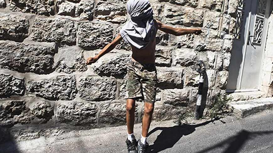 A Palestinian boy uses a sling to throw a stone during clashes with Israeli police following Friday prayers in the East Jerusalem neighbourhood of Ras Al Amoud September 27, 2013. An Israeli police spokesman said on Friday that 10 Palestinians were detained on suspicion of throwing stones at policemen who were deployed in the Old City and in nearby Palestinian neighbourhoods of Jerusalem, amid recent tensions over Israel's admittance of Jewish visitors to a holy site in the Old City, which houses the al-Asq