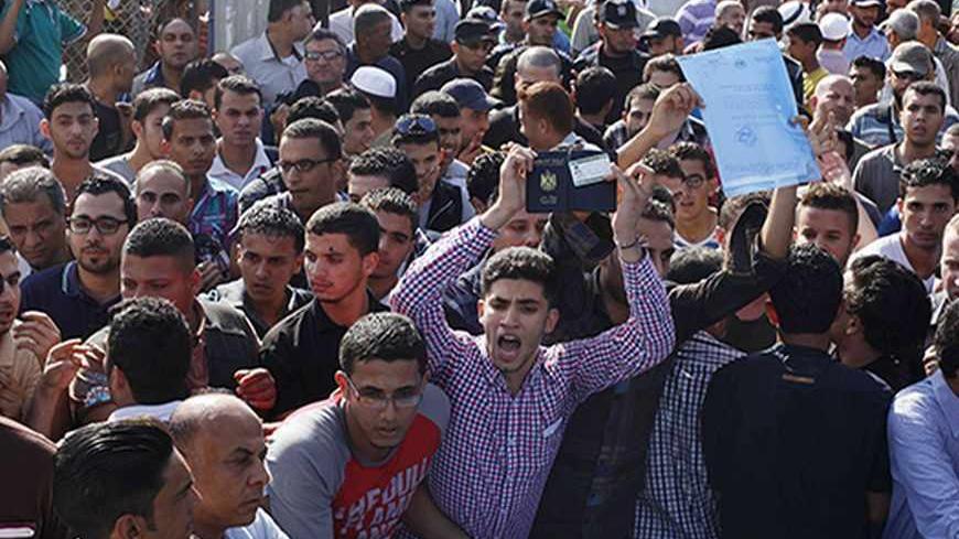 Passengers gather around the gate of Rafah crossing with Egypt as they protest against the conditions on the crossing, with hopes of crossing into Egypt, September 18, 2013. Egypt partially reopened its border crossing with the Gaza Strip on Wednesday, a week after it was closed in response to a deadly attack on an Egyptian military headquarters near the frontier. Officials of the Palestinian Authority, the West Bank-based rival of Gaza's Hamas Islamist rulers, said Cairo agreed to open the crossing for fou