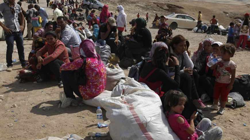 Syrian refugees, fleeing the violence in their country, wait to cross the border into the autonomous Kurdish region of northern Iraq, August 21, 2013.  The government of Iraqi Kurdistan has set an entry quota of 3,000 refugees a day to cope with an influx of Kurds fleeing the civil war in Syria, but there are signs many more are still coming in, aid agencies said on Tuesday. REUTERS/Thaier al-Sudani (IRAQ - Tags: CIVIL UNREST POLITICS SOCIETY IMMIGRATION) - RTX12SKT