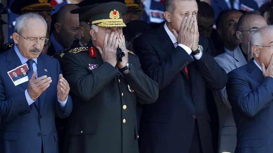 (L-R) Turkey's main opposition Republican People's Party Leader Kemal Kilicdaroglu, Chief of Staff General Necdet Ozel, Prime Minister Tayyip Erdogan and Chairman of the Parliament Cemil Cicek pray as they attend an official farewell ceremony for fallen Turkish pilots, Captain Gokhan Ertan and Lieutenant Hasan Huseyin, at the 7th Jet Main Air Base in the eastern Turkish city of Malatya July 6, 2012. Turkish Prime Minister Tayyip Erdogan and top military officials attend the funeral of the two pilots of the