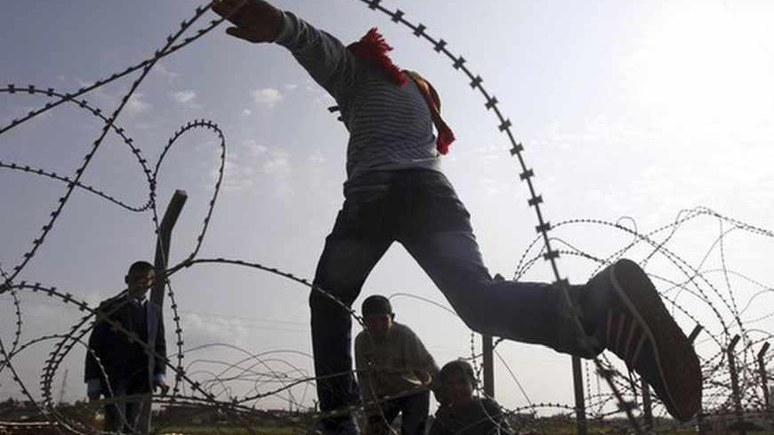 Syrian boys from the northern Syrian town of Ras al-Ain attempt to cross the border back into Syria at the Turkish border town of Ceylanpinar, Sanliurfa province, November 24, 2012. Syria on Friday condemned Turkey's request for NATO to deploy Patriot defence missiles near their common border, calling it "provocative", after a spate of clashes there that has raised fear of the Syrian civil war embroiling the wider region. REUTERS/Amr Abdallah Dalsh (TURKEY - Tags: CIVIL UNREST MILITARY POLITICS CONFLICT) -