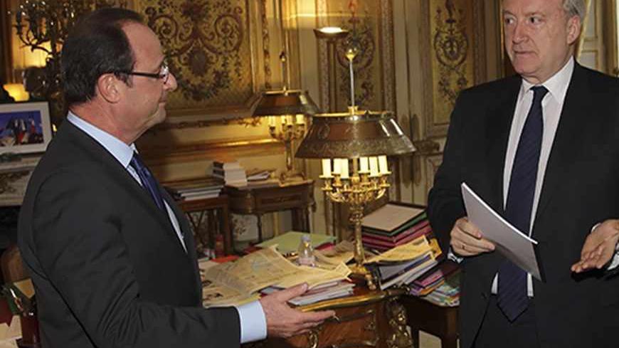 France's President Francois Hollande (L) receives a report which review France's membership of NATO's integrated military command from former French Foreign Minister Hubert Vedrine (R) during a meeting at the Elysee Palace in Paris, November 14, 2012.  REUTERS/Philippe Wojazer  (FRANCE - Tags: POLITICS MILITARY) - RTR3ADPO