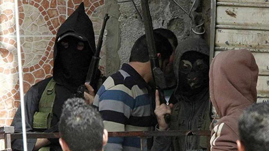 Two masked gunmen stand with their weapons at Ain al-Hilweh Palestinian refugee camp near the port city of Sidon in south Lebanon, March 12, 2013. Ten people were wounded and one killed during clashes between Fatah movement and radical Islamists that started on Monday. REUTERS/Ali Hashisho (LEBANON - Tags: POLITICS CIVIL UNREST) - RTR3EW3P