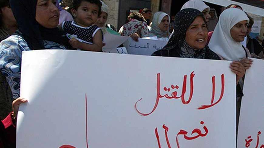 RAMALLAH, -: Palestinian women hold up banners reading "No to killing, yes to life" as they demonstrate against the "crimes of honor" in some traditional and rural Palestinian communities in which female vitue and virginity still defines a family's reputation, 10 September 2005 in Ramallah. Honor killing in some Arab societies occurrs when women accused in sexual misconduct are murdered by close relatives who are encourged by their families to "cleanse" the honor of the family that has been "disgraced." AF