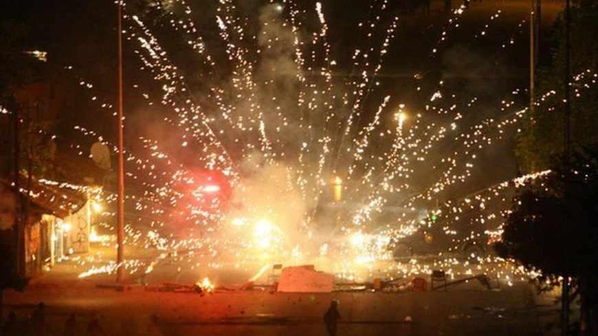 Turkish riot police are targeted with fireworks during a protest against a government project, the first ever cultural center containing an Alevi cemevi and a Sunni mosque side by side, in Tuzlucayir neighborhood of Ankara, on September 12, 2013 AFP PHOTO/ADEM ALTAN (Photo credit should read ADEM ALTAN/AFP/Getty Images)