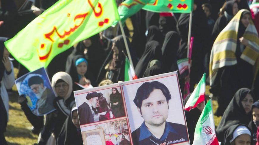 EDITORS' NOTE: Reuters and other foreign media are subject to Iranian restrictions on leaving the office to report, film or take pictures in Tehran.

A demonstrator holds a picture of assassinated scientist and member of Iran's Atomic Energy Organization, Dariush Rezaeinejad, during a ceremony to mark the 33rd anniversary of the Islamic Revolution, in Tehran's Azadi square February 11, 2012. Iran's President Mahmoud Ahmadinejad said on the anniversary of the revolution that the Islamic Republic would soon