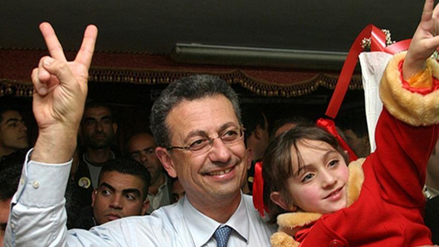 Former Palestinian presidential election candidate Mustafa Barghouti holds a young girl during a rally in Hebron. Former Palestinian presidential election candidate Mustafa Barghouti (L), who is secretary general of al-Mubadara Palestinian National committee, holds a young girl during a rally in the West Bank City of Hebron January 14, 2005. REUTERS/Nayef Hashlamoun - RTRKJ5J