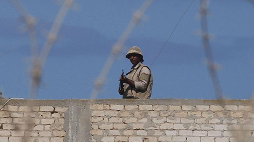 An Egyptian soldier guards the border between Egypt and southern Gaza Strip September 16, 2013. The Egyptian army is clearing buildings deemed a security threat at a distance of up to one km (0.6 miles) from the Gaza border, an army spokesman said on Sunday, accusing groups in the Hamas-run territory of mounting joint attacks with Sinai militants. REUTERS/Ibraheem Abu Mustafa (EGYPT - Tags: POLITICS MILITARY) - RTX13N6S