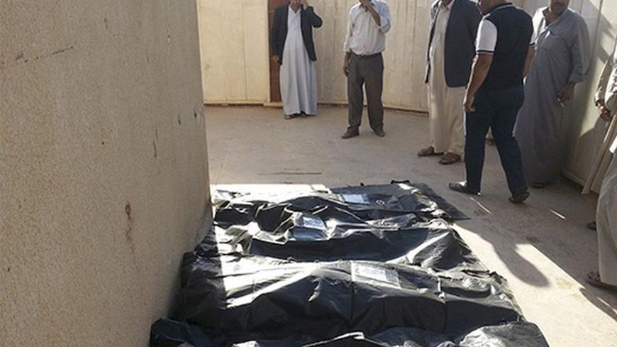 Civilians look at the bodies of victims of an attack in the village of Mwafaqiya, in Nineveh province, October 17, 2013. A suicide bomber driving a truck packed with explosives blew himself up in a village in northern Iraq, killing at least 11 people early on Thursday, police said. The attack targeted members of Iraq's predominantly Shi'ite Shabak minority in the village of Mwafaqiya in Nineveh province.    REUTERS/Stringer (IRAQ - Tags: CIVIL UNREST POLITICS) - RTX14F5M