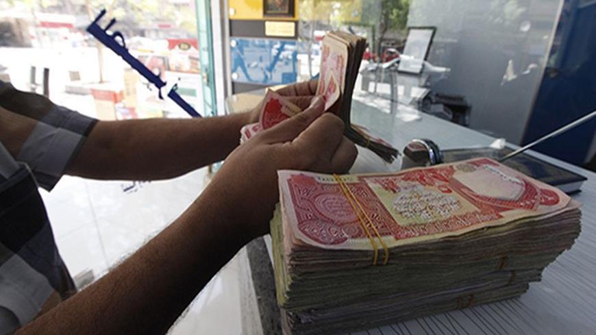 A customer counts Iraqi dinars at a money changer in Baghdad October 1, 2012. Many Iraqis have lost faith in their dinar currency but to some foreign speculators, it promises big profits. The contrast underlines the uncertainties of investing in Iraq as the country recovers from years of war and economic sanctions. Picture taken October 1, 2012. To match IRAQ-ECONOMY/DINAR  REUTERS/Saad Shalash (IRAQ - Tags: BUSINESS POLITICS) - RTR38QU1