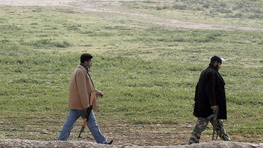 Members of the Free Syrian Army patrol in the northern Syrian town of Ras al-Ain as they are pictured from the Turkish border town of Ceylanpinar, Sanliurfa province January 26, 2013. REUTERS/Osman Orsal (TURKEY - Tags: POLITICS CONFLICT) - RTR3CZ0L