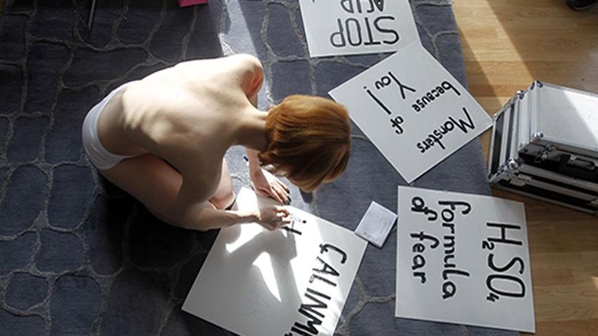 An activist of the women's rights group Femen prepares for a protest against domestic violence in Istanbul March 8, 2012.  REUTERS/Osman Orsal (TURKEY - Tags: CIVIL UNREST) TEMPLATE OUT - RTR2Z1A9