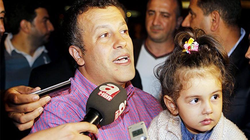 Turkish Airlines pilot Murat Agca talks to media at Istanbul's Ataturk airport October 19, 2013. Prime Minister Tayyip Erdogan personally greeted two kidnapped Turkish pilots when they arrived back in Istanbul on Saturday after two months in captivity in Lebanon. The pair were released earlier under a deal whereby nine Lebanese hostages were freed in Syria and allowed to return home via Turkey. The Turkish pilots had been abducted in retaliation for the snatching of the Lebanese. REUTERS/Osman Orsal (TURKEY