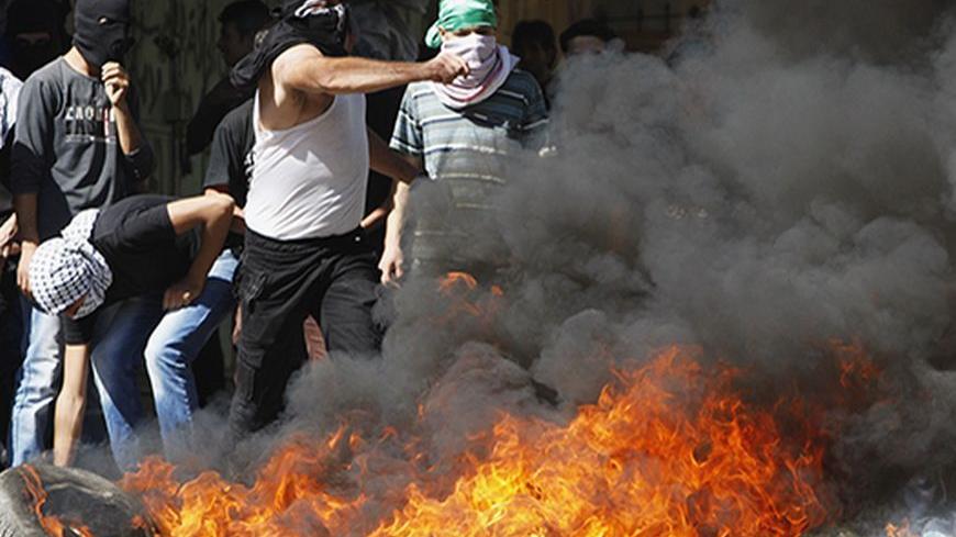Palestinian protesters throw stones at Israeli security forces during clashes in the West Bank city of Hebron September 27, 2013. Israeli police clashed with Palestinian protesters in Jerusalem's Old City, the Gaza Strip and the occupied West Bank on Friday, reflecting growing tensions over an increase in Jewish visits to the al-Aqsa mosque. REUTERS/Mussa Qawasma  (WEST BANK - Tags: POLITICS CIVIL UNREST RELIGION) - RTX1426K