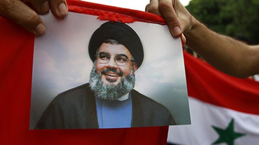 Protesters shout slogans as they hold an image of Lebanon's Hezbollah leader Sayyed Hassan Nasrallah during a demonstration against the possibility of a U.S. military strike against the Syrian government, in Tunis September 10, 2013. REUTERS/Anis Mili (TUNISIA - Tags: POLITICS CIVIL UNREST) - RTX13G1N