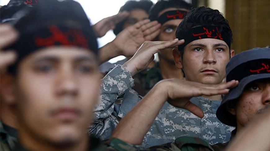 Iraqi Shi'ite fighters salute to the shrine of Sayeda Zeinab, the granddaughter of Prophet Mohammad, at Sayeda Zainab area in Damascus May 25, 2013. Picture taken May 25, 2013. REUTERS/ Alaa Al-Marjani (SYRIA - Tags: CIVIL UNREST POLITICS MILITARY CONFLICT) ) - RTX104SW