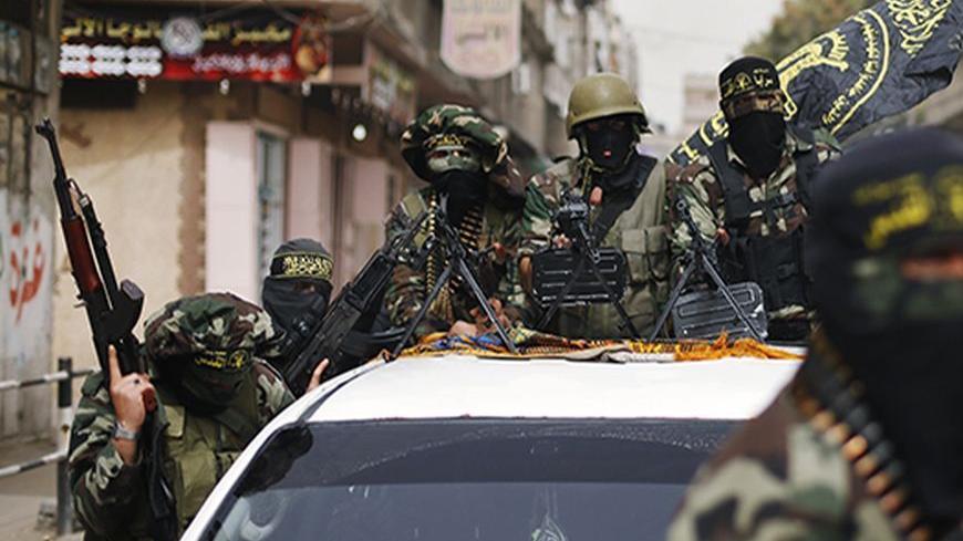Islamic Jihad militants ride on a pickup truck as they follow the convoy of freed Palestinian prisoner Ibrahim Baroud, upon his arrival in the northern Gaza Strip April 8, 2013. Baroud, who was convicted of his affiliation with the armed group of Islamic Jihad and for carrying out armed attacks against Israel, was released on Monday after serving 27 years in an Israeli jail, according to media reports.  REUTERS/Mohammed Salem (GAZA - Tags: POLITICS) - RTXYD6V