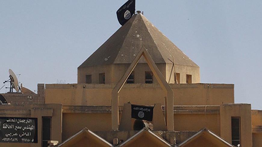 Flags of the al-Qaeda linked Islamic State of Iraq and the Levant are hung on The Martyrs Church in Raqqa city centre September 27, 2013. The Al-Qaeda linked Islamic State of Iraq and the Levant removed crosses from The Martyrs Church in Raqqa and hoisted their flags on Thursday, activists say. REUTERS/Stringer (SYRIA - Tags: RELIGION CIVIL UNREST CONFLICT) - RTX14223