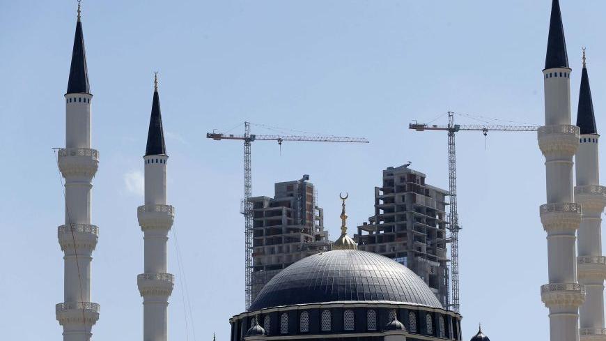 The construction of a residential tower is seen behind the newly built Mimar Sinan mosque in Atasehir on the Asian side of Istanbul in this September 4, 2012 file photo. Perched on the edge of a wasteland earmarked to become a financial district on Istanbul's Asian side, the curved facades of five massive luxury tower blocks sparkle in the sunshine, the centrepiece of a sprawling new residential complex. It is the sort of development that overseas property buyers in Turkey, mainly from Europe, have usually