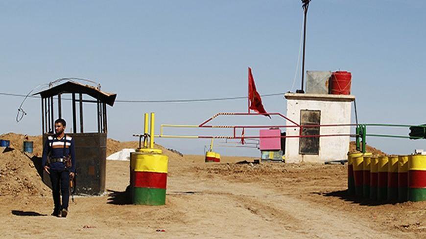 An officer of the Syrian Kurdish Democratic Union Party (PYD) stands guard near the Syrian-Iraq border October 31, 2012. Iraqi Kurdish President Masoud Barzani warned Kurds in Syria against being sucked into the "fires of discord," urging them to preserve Kurdish unity as tensions between rival factions threaten to spillover into violence. Syria's Kurds see the war ravaging their country as an unprecedented opportunity to gain the kind of freedoms enjoyed by their ethnic kin in neighbouring Iraq, where they