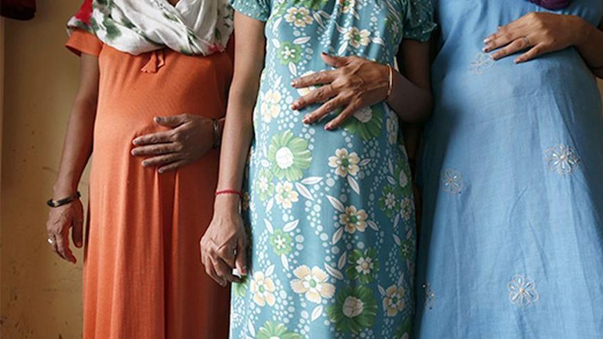 Surrogate mothers (L-R) Daksha, 37, Renuka, 23, and Rajia, 39, pose for a photograph inside a temporary home for surrogates provided by Akanksha IVF centre in Anand town, about 70 km (44 miles) south of the western Indian city of Ahmedabad August 27, 2013. India is a leading centre for surrogate motherhood, partly due to Hinduism's acceptance of the concept. The world's second test tube baby was born in Kolkata only two months after Louise Brown in 1978. Rising demand from abroad for Indian surrogate mother
