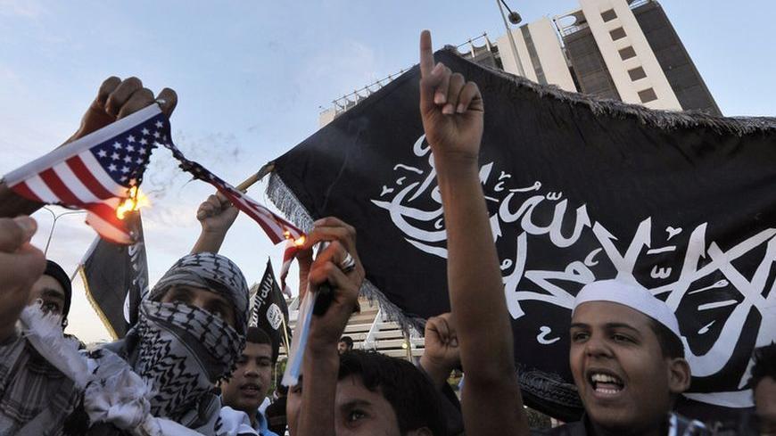 Protesters burn a replica of the U.S. flag during a demonstration against the capture of Nazih al-Ragye, in Benghazi October 7, 2013. An elite U.S. interrogation team is questioning the senior al Qaeda figure, better known by the cover name Abu Anas al-Liby, who was seized by special operations forces in Libya and then whisked onto a Navy ship in the Mediterranean Sea, U.S. officials said on Monday.    REUTERS/Esam Omran Al-Fetori     (LIBYA - Tags: CIVIL UNREST POLITICS) - RTX14315