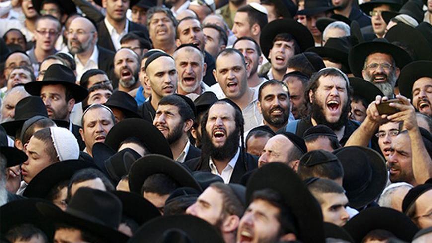 Ultra-Orthodox Jewish men mourn during the funeral of Rabbi Ovadia Yosef, the spiritual leader of the ultra-religious Shas political party, in Jerusalem October 7, 2013.  More than half a million mourners turned out on Monday for the funeral of Yosef, an Iraqi-born sage who transformed an Israeli underclass of Sephardic Jews of Middle East heritage into a powerful political force. REUTERS/Baz Ratner (JERUSALEM - Tags: POLITICS RELIGION OBITUARY) - RTX1431P
