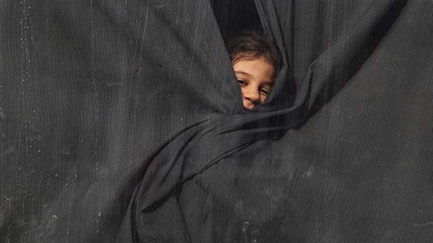 A Palestinian girl, who had been living at Yarmouk Palestinian refugee camp in Syria, looks out of a bus window, as the bus arrives at the Lebanese-Syrian border, in al-Masnaa December 18, 2012. More than 1,000 Palestinian refugees living in Syria have crossed into Lebanon in the past 24 hours, a source at the Lebanese border said on Tuesday, after Syrian rebels took control of a Palestinian refugee camp in Damascus. REUTERS/Jamal Saidi (LEBANON - Tags: POLITICS CIVIL UNREST SOCIETY) - RTR3BPTI
