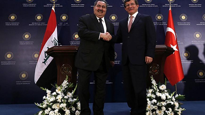 Turkey's Foreign Minister Ahmet Davutoglu (R) shakes hands with his Iraqi counterpart Hoshiyar Zebari after a news conference in Ankara October 25, 2013. REUTERS/Umit Bektas (TURKEY - Tags: POLITICS) - RTX14NP6