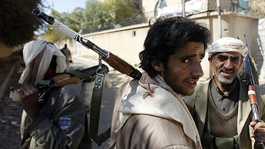 Tribal fighters loyal to al-Ahmar family, which leads Yemen's powerful tribe of Hashid, carry their AK-47 rifles as they secure a street where recent clashes with government forces took place in Sanaa December 21, 2011.  REUTERS/Khaled Abdullah (YEMEN - Tags: POLITICS CIVIL UNREST) - RTR2VIKY
