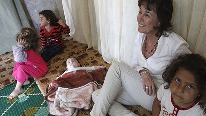 UNHCR's Representative in Lebanon Ninette Kelley sits with Syrian refugee children inside a makeshift room in Alman town, in the Shouf area in Mount Lebanon, during her visit to the refugees on the occasion of the World Refugee Day, June 20, 2013. REUTERS/Ali Hashisho  (LEBANON - Tags: POLITICS CIVIL UNREST SOCIETY IMMIGRATION) - RTX10UV3